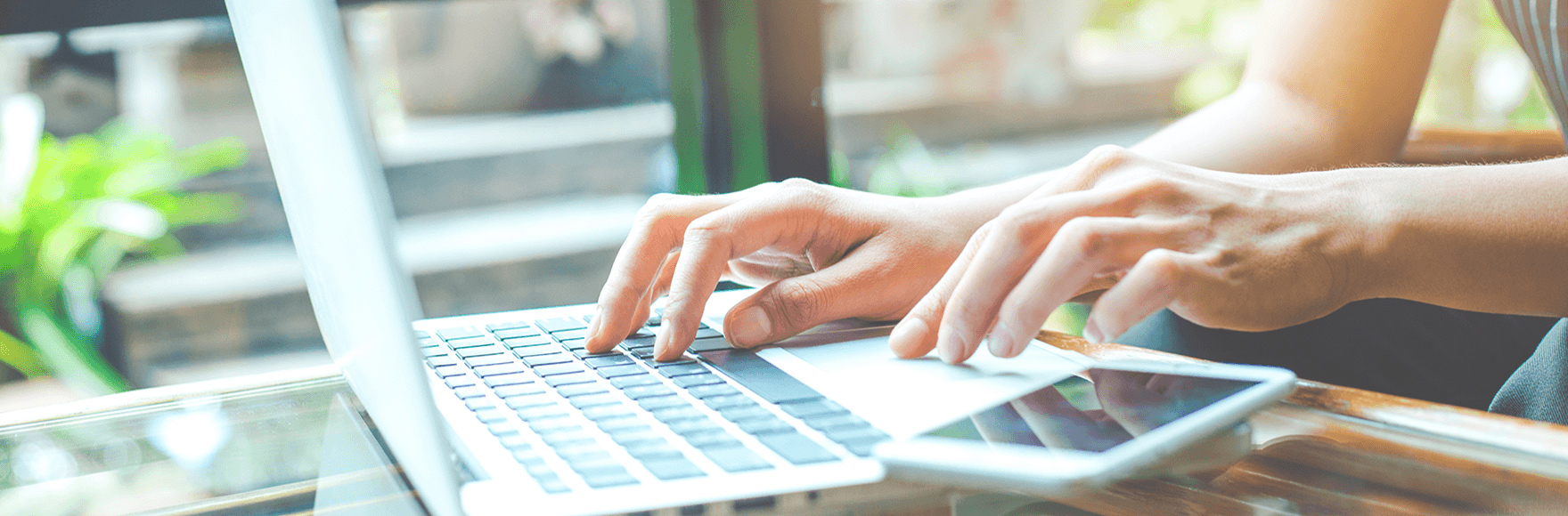 a person typing on their laptop computer